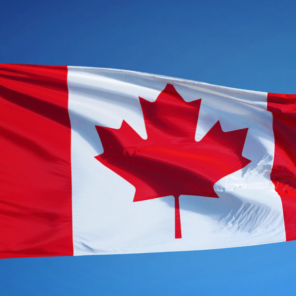 Canada flag waving against clean blue sky, close up, isolated with clipping mask alpha channel transparency, perfect for film, news, digital composition